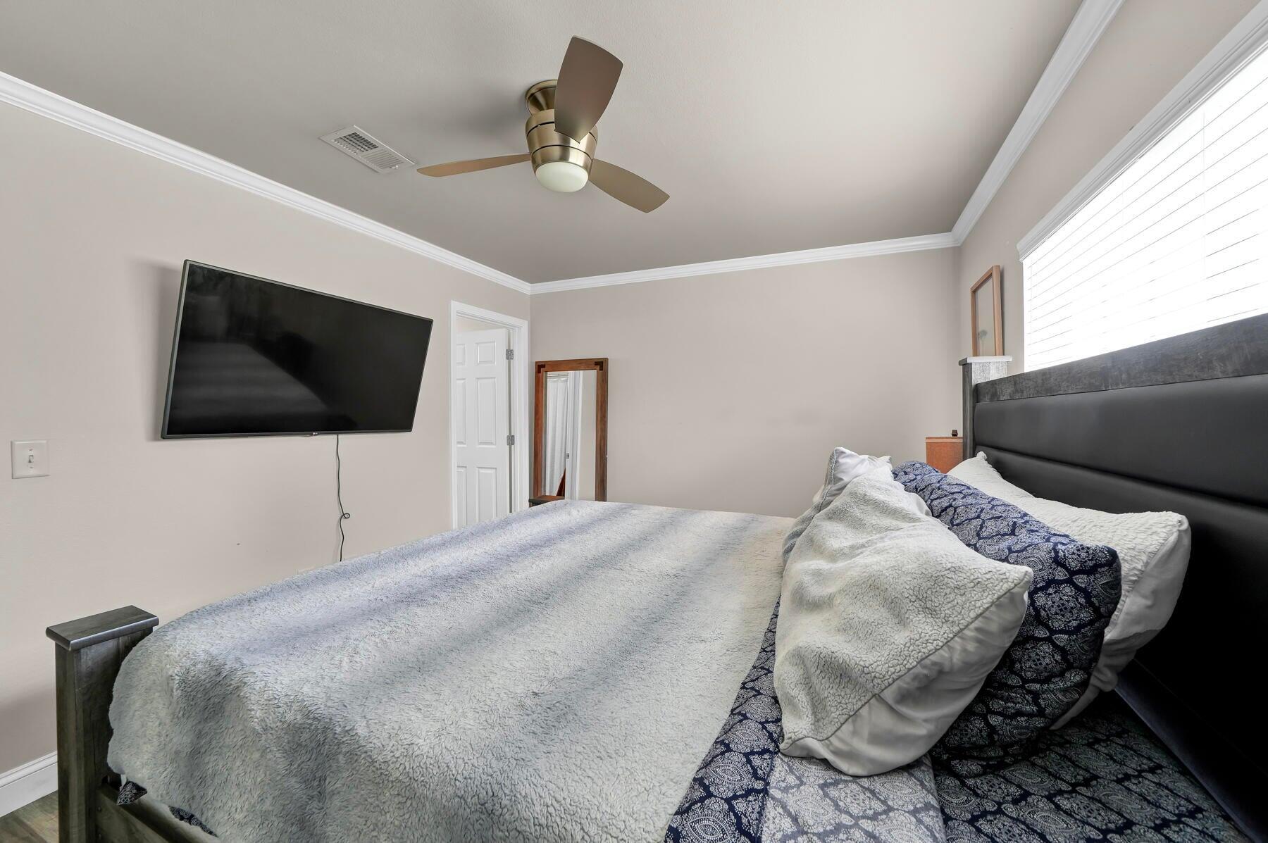 562 Wingspan Way Crestview, FL 32536 - Photo 9 of 12 a bedroom with a bed a flat screen tv and a window