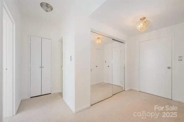 a view of a hallway with a chandelier fan