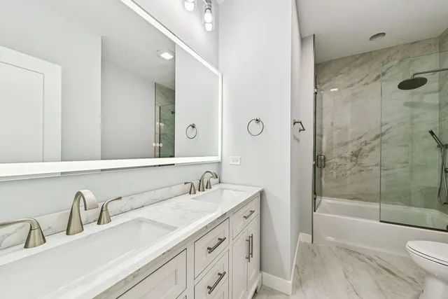 a bathroom with a granite countertop sink double mirror shower and a bathtub