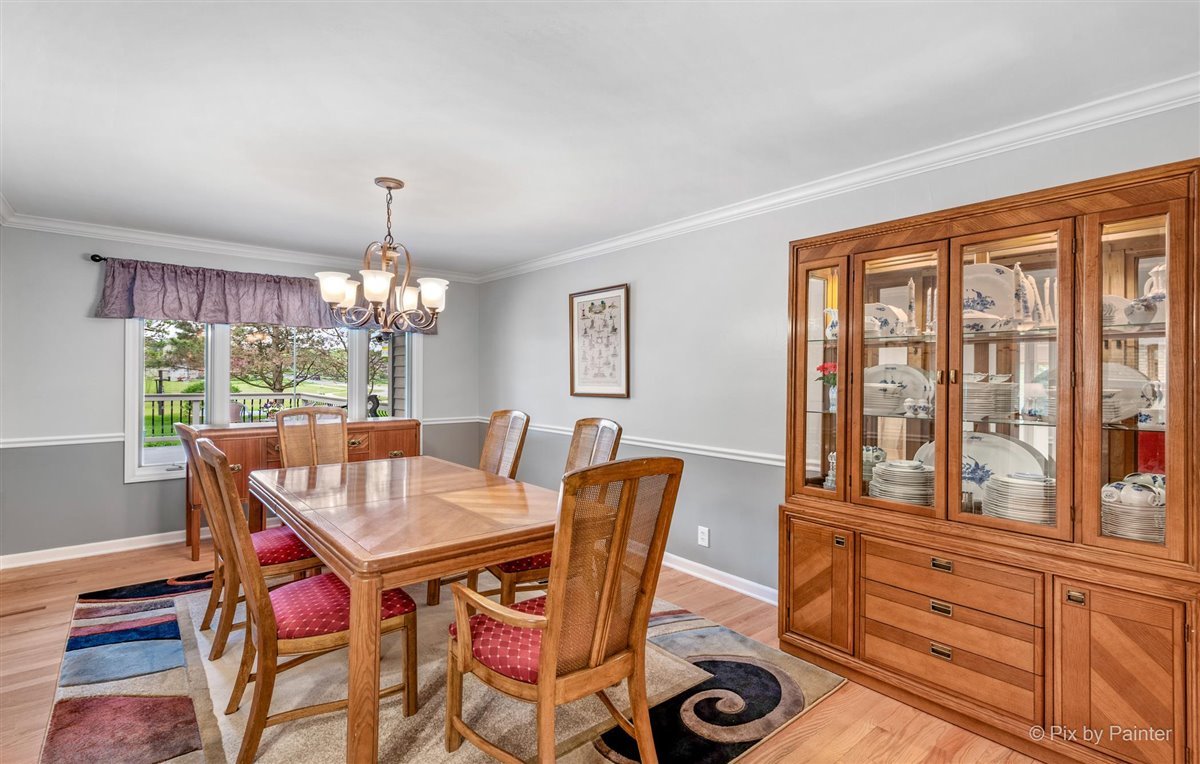724 Ridgelawn Trail Batavia, IL 60510 - Photo 12 of 32 a view of a dining room with furniture a chandelier and wooden floor