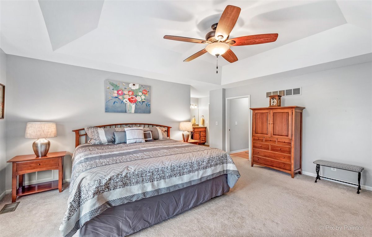 724 Ridgelawn Trail Batavia, IL 60510 - Photo 16 of 32 a bedroom with a bed and a chandelier