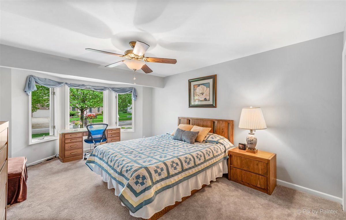 724 Ridgelawn Trail Batavia, IL 60510 - Photo 20 of 32 a bedroom with a large bed and a chandelier