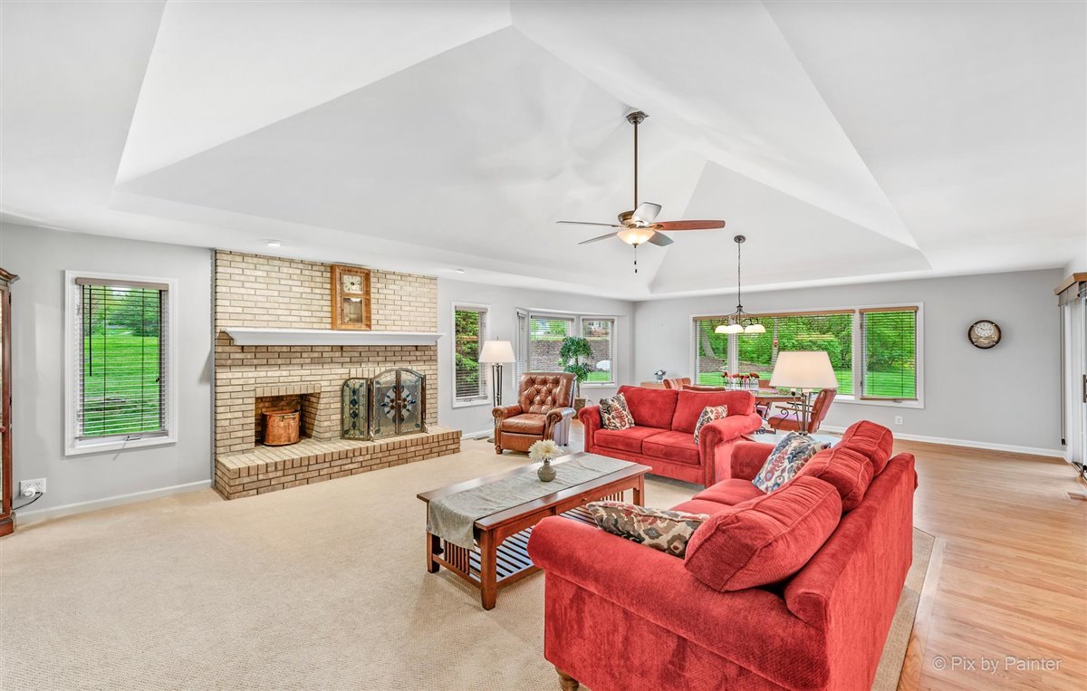 724 Ridgelawn Trail Batavia, IL 60510 - Photo 5 of 32 a living room with furniture a fireplace and a chandelier