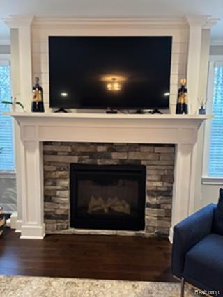 2500 Walnut View Drive Howell, MI 48855 - Photo 9 of 41 Detailed view of a stone fireplace, crown molding, and wood finished floors
