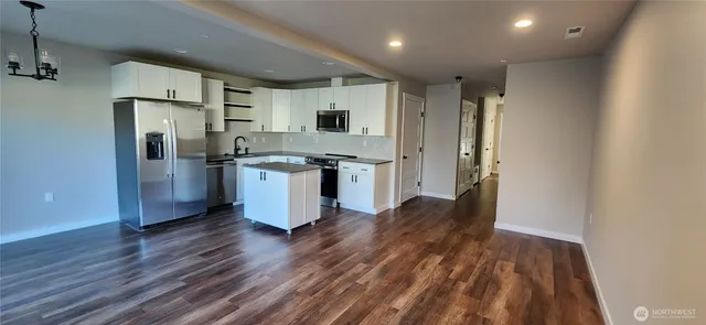 a kitchen with stainless steel appliances granite countertop a refrigerator and a stove top oven
