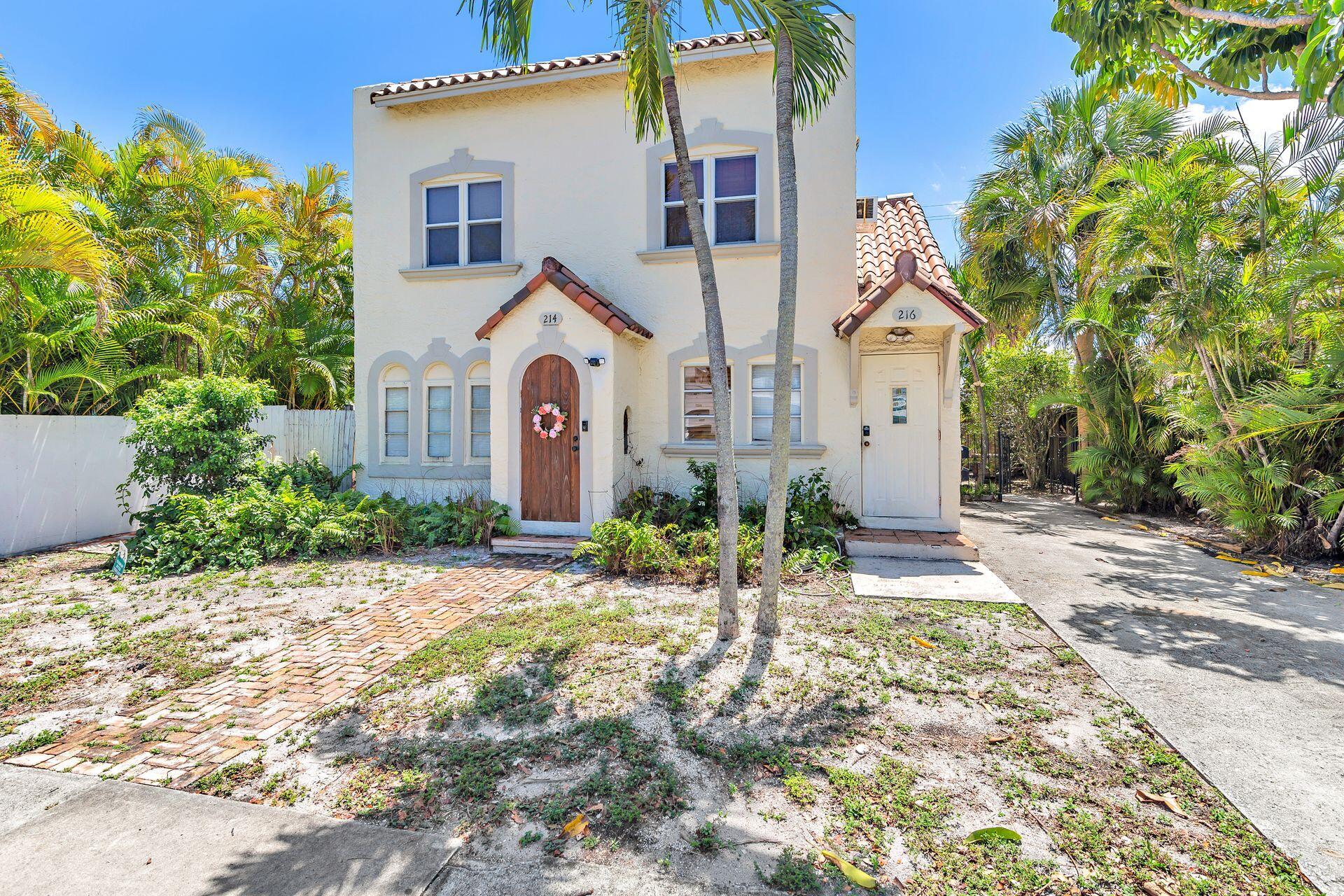 214 Conniston Road West Palm Beach, FL 33405 - Photo 1 of 18 a view of a white house with a clock on the side of it