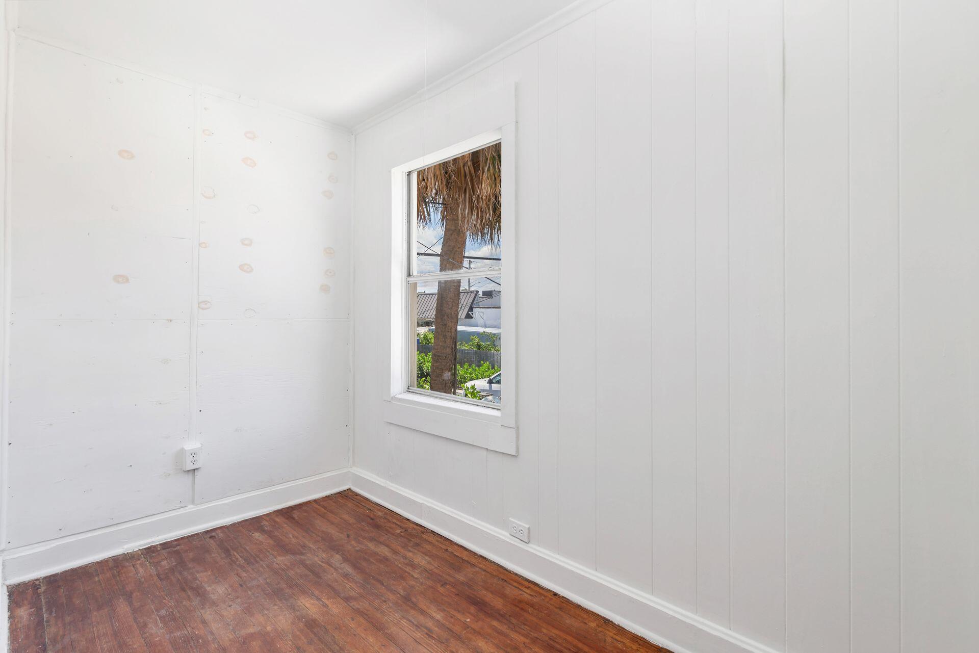 214 Conniston Road West Palm Beach, FL 33405 - Photo 7 of 18 a view of an empty room with wooden floor and a window