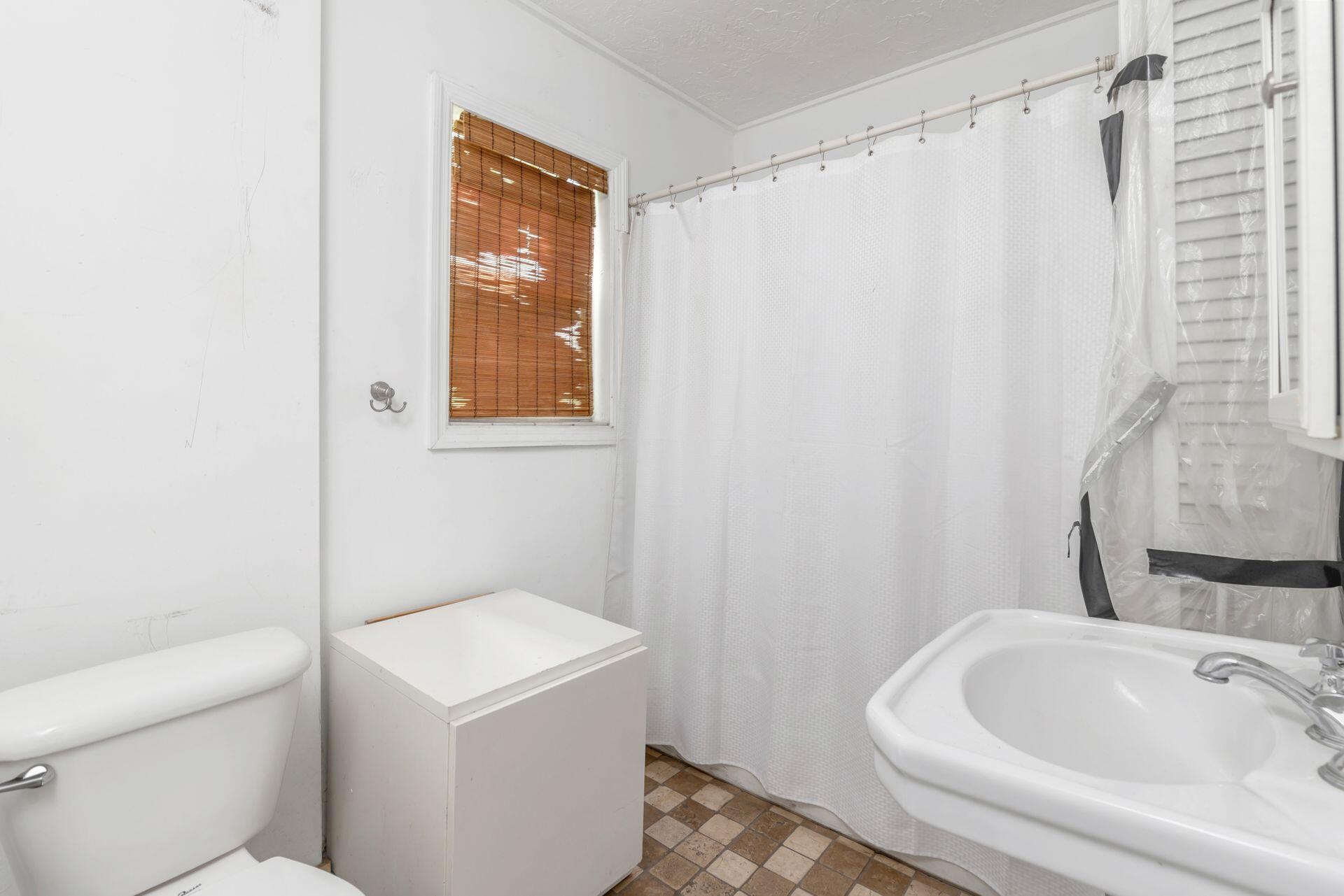214 Conniston Road West Palm Beach, FL 33405 - Photo 10 of 18 a bathroom with a sink a toilet and shower curtain