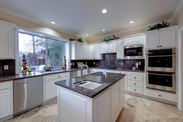 a kitchen with a sink a microwave and cabinets