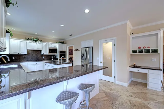 a large kitchen with stainless steel appliances lots of counter space and breakfast area