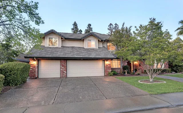 a front view of a house with a yard and potted plants