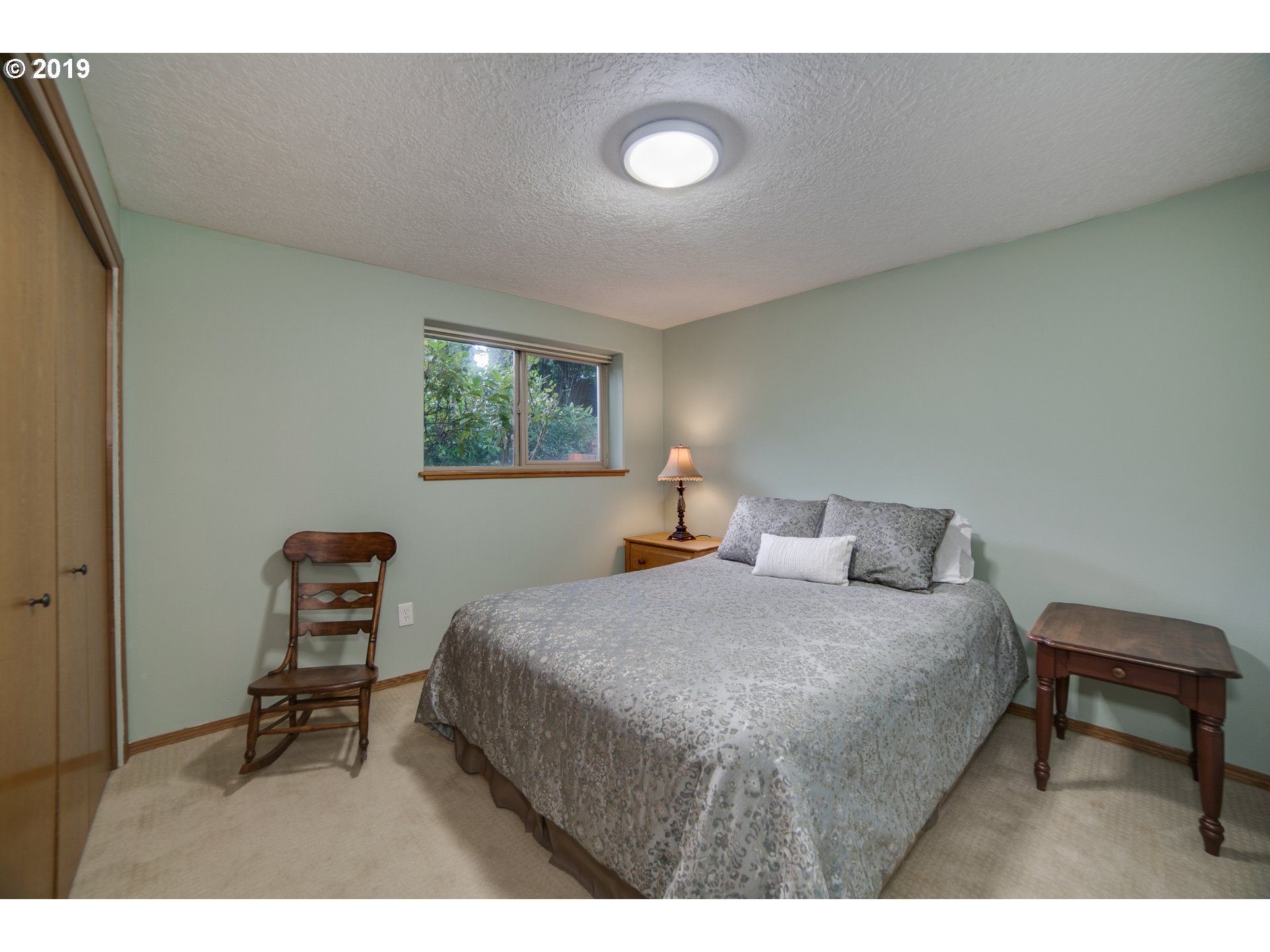 1119 Southwest 1st Street Dundee, OR 97115 - Photo 21 of 32 a bedroom with a bed a chair and a window
