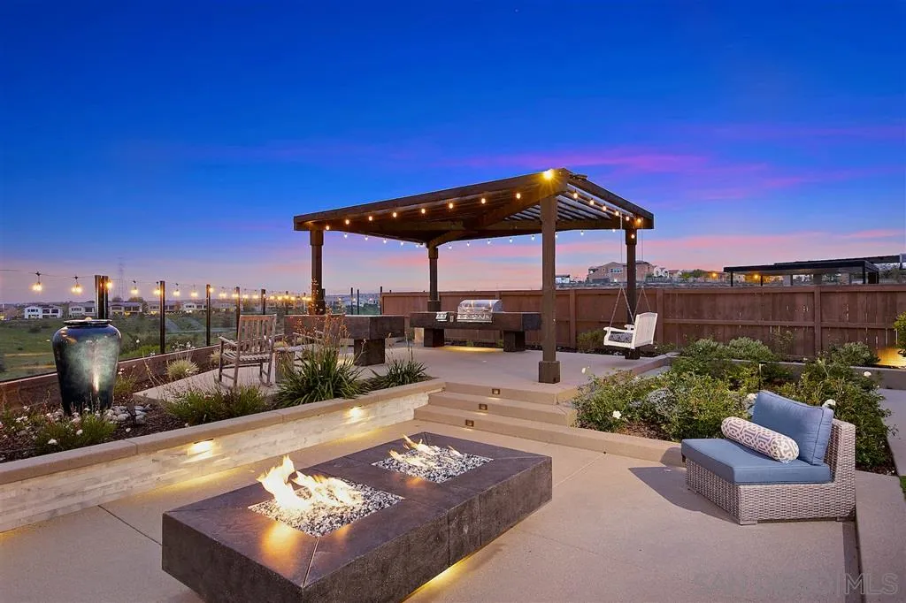16438 Nicole Ridge Road San Diego, CA 92127 - Photo 18 of 25 a view of a patio with couches chairs under an umbrella with a fire pit