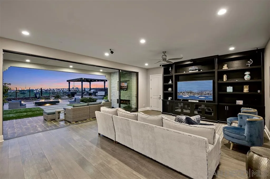 16438 Nicole Ridge Road San Diego, CA 92127 - Photo 3 of 25 a living room with furniture a flat screen tv and a floor to ceiling window