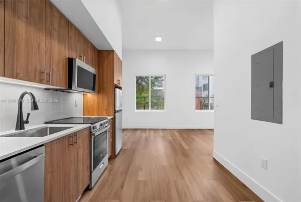 a kitchen with stainless steel appliances granite countertop a sink a stove and a wooden floors