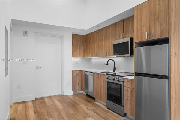 a kitchen with stainless steel appliances a refrigerator stove and microwave