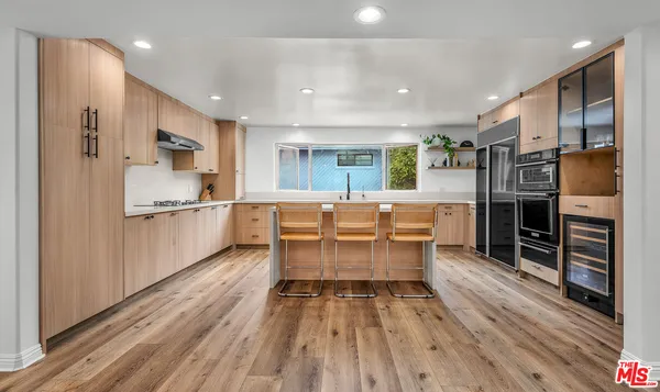 a kitchen with stainless steel appliances kitchen island granite countertop a refrigerator and a stove top oven