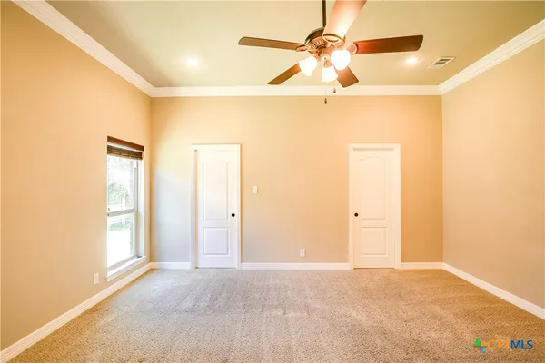 an empty room with windows and fan