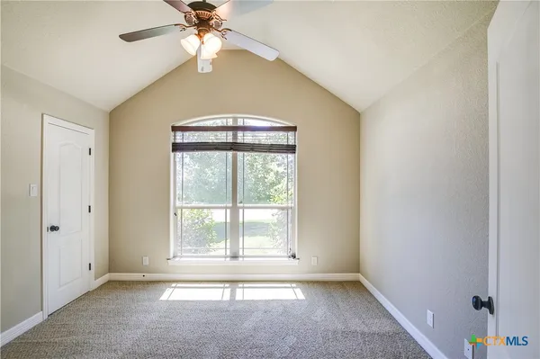 an empty room with windows and fan
