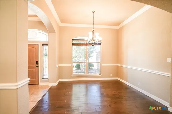 a view of a livingroom with a fireplace a chandelier and wooden floor