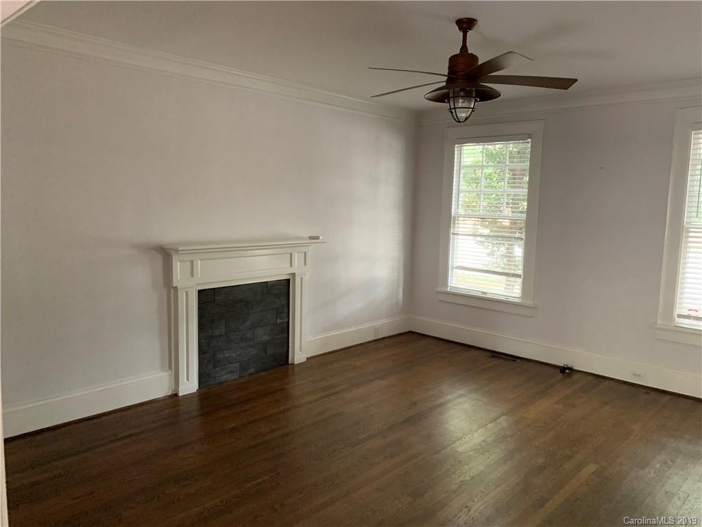 224 Providence Road Charlotte, NC 28207 - Photo 10 of 27 an empty room with wooden floor a ceiling fan and windows