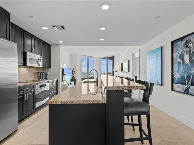 a bedroom with a bed dresser and a large window