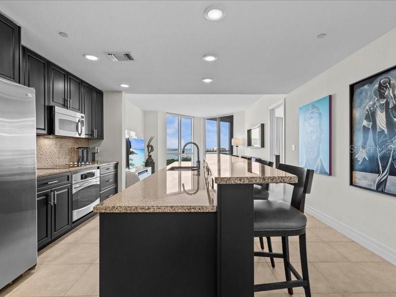 331 Cleveland Street, Unit 806 Clearwater, FL 33755 - Photo 2 of 83 a large kitchen with granite countertop a stove a sink a dining table and chairs