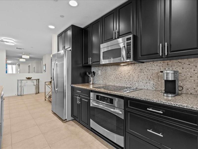 331 Cleveland Street, Unit 806 Clearwater, FL 33755 - Photo 27 of 83 a kitchen with stainless steel appliances granite countertop a stove a refrigerator and a microwave
