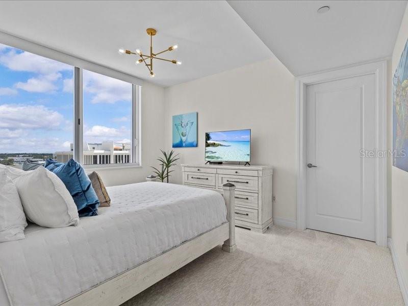 331 Cleveland Street, Unit 806 Clearwater, FL 33755 - Photo 49 of 83 a bedroom with a bed and a chandelier
