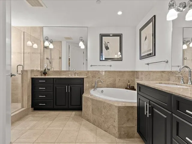 a bathroom with a tub shower and checkered floor
