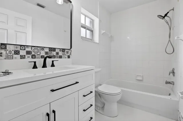 an empty room with wooden floor ceiling fan and windows