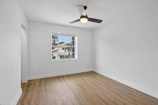 a view of a room with wooden floor and a ceiling fan