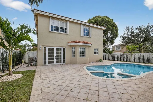 a view of a house with swimming pool and sitting area