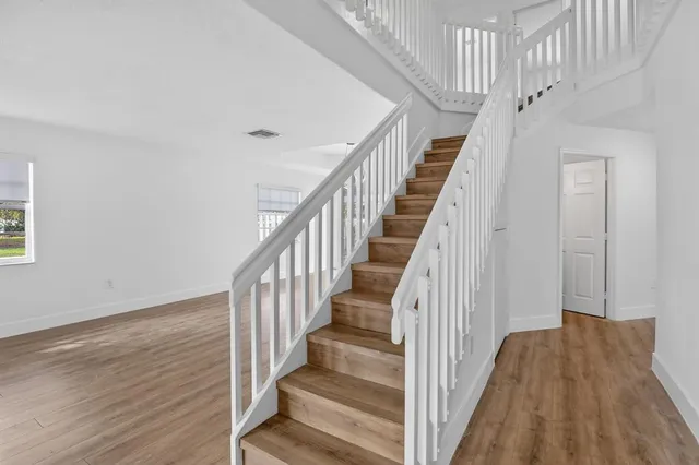 a view of staircase with wooden floor and white walls