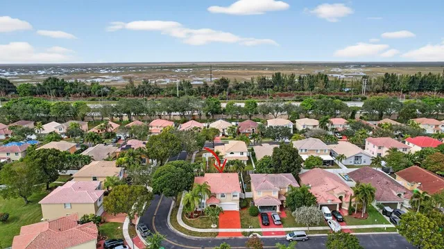 an aerial view of lake and residential houses with outdoor space and swimming pool