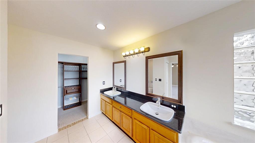 9761 Southwest 90th Street Ocala, FL 34481 - Photo 18 of 27 a bathroom with a double vanity sink and mirror