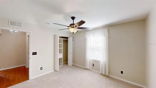 a view of a livingroom with a ceiling fan and window