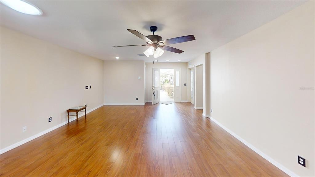 9761 Southwest 90th Street Ocala, FL 34481 - Photo 3 of 27 a view of a room with a ceiling fan and wooden floor