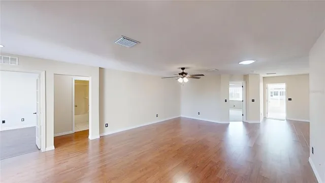 a view of an empty room with wooden floor