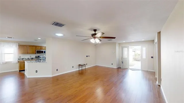 a view of a kitchen with wooden floor and a ceiling fan