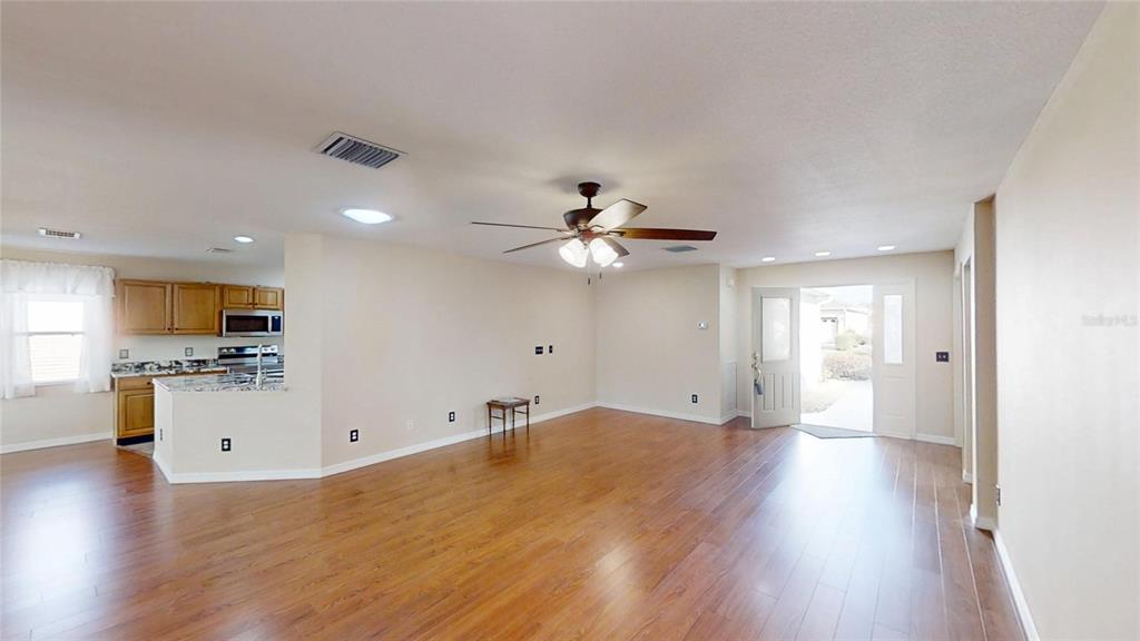 9761 Southwest 90th Street Ocala, FL 34481 - Photo 5 of 27 a view of a kitchen with wooden floor and a ceiling fan