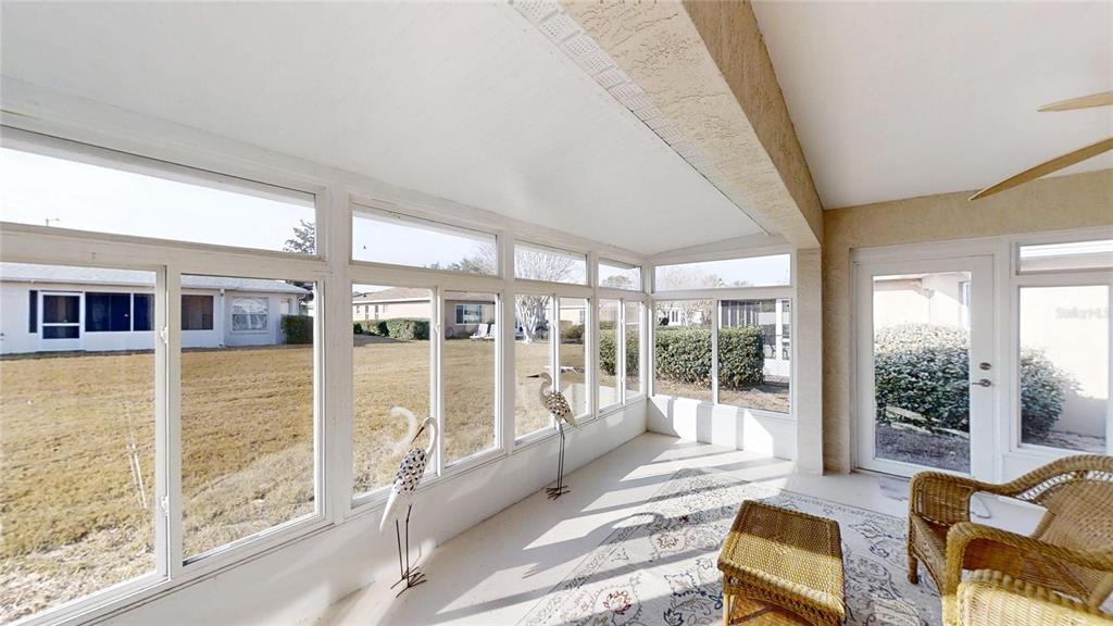 9761 Southwest 90th Street Ocala, FL 34481 - Photo 7 of 27 a living room with furniture floor to ceiling windows and walls