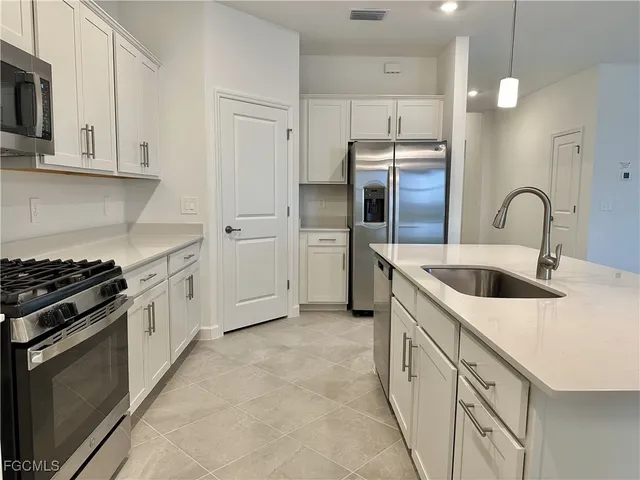 a kitchen with white cabinets and stainless steel appliances