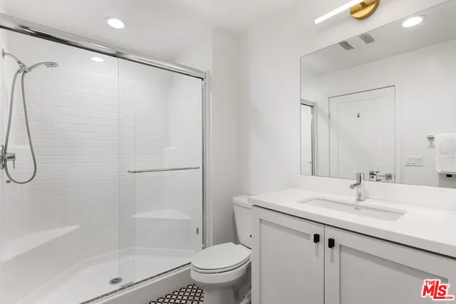 a bathroom with a granite countertop sink toilet and shower