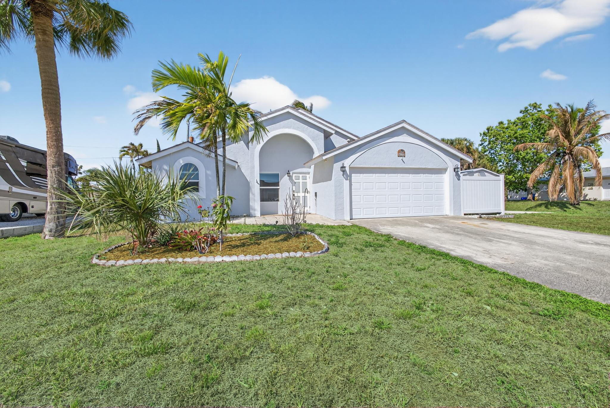 6223 Kendrick Street Jupiter, FL 33458 - Photo 1 of 45 a front view of a house with garden