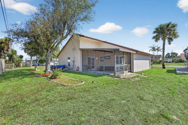 a view of a house with backyard and sitting area