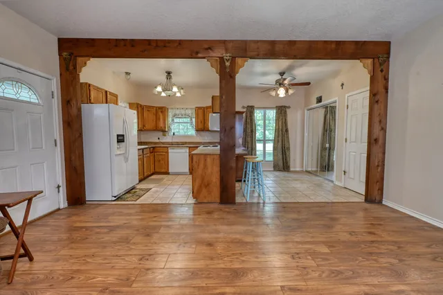 a view of a living room and kitchen with stainless steel appliances wooden floor
