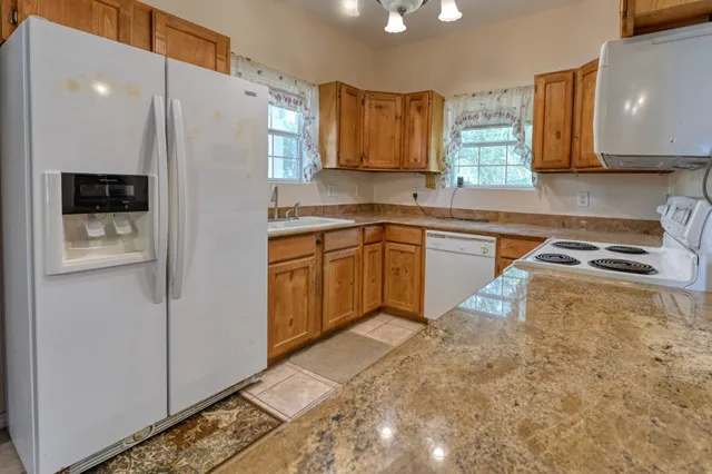 a kitchen with stainless steel appliances granite countertop a refrigerator sink and microwave