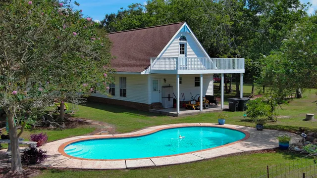 a view of a house with swimming pool and yard