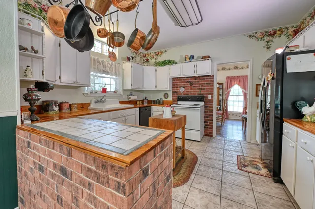 a kitchen with stainless steel appliances granite countertop a sink a stove counter space and cabinets